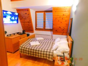 a small bedroom with a bed and a television at Aparthotel Vučko Apartment Lora in Jahorina