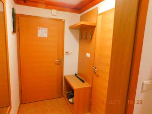 La salle de bains est pourvue d'une porte en bois et d'une table en bois. dans l'établissement Aparthotel Vučko Apartment Lora, à Jahorina