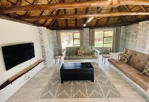 a living room with a couch and a tv at Charihandra Game Lodge in Addo