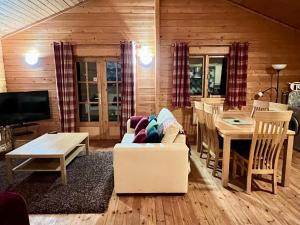 a living room with a white couch and a table at Tufty Lodge, Lake Pochard lodge 9 in South Cerney
