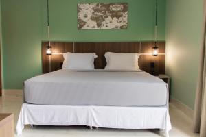 a white bed in a room with green walls at Búri Resort in Manaus