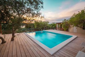 una piscina en una terraza con una casa en Olivia Green Camping en Tisno