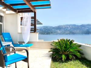 um pátio com cadeiras azuis e vista para a água em Atrium Blue Holiday House em Ražanac