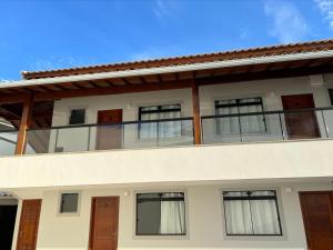 an external view of a house with a balcony at Arraial do Cabo Village Pôr Do Sol in Arraial do Cabo