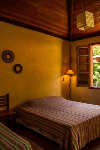 1 dormitorio con cama y ventana en Pousada Opicodocipo, en Santana do Riacho