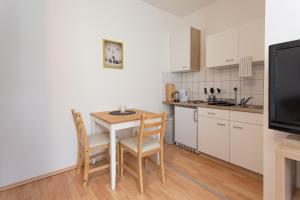 eine Küche mit Tisch und Stühlen und einem Fernseher in der Unterkunft FullHouse - Chemnitz - S35 Little Sun - Elevator in Chemnitz