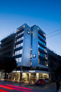 un edificio azul con coches estacionados frente a él en NLH FIX | Neighborhood Lifestyle Hotels, en Atenas