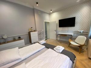 Dormitorio con cama, escritorio y TV en Maya's Flats & Resorts 44 - Chlebnicka 17/18, en Gdansk