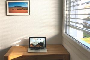 een laptop op een houten tafel naast een raam bij BnB 5430 in Wettingen
