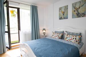 Un dormitorio con una cama azul y una ventana. en Apartament Maza, en Sinaia