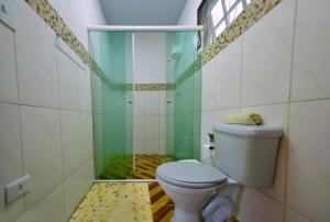 a bathroom with a toilet and a shower at Casa à beira do rio Jaguareguava na Mata Atlântica em Bertioga SP in Bertioga +35 photos