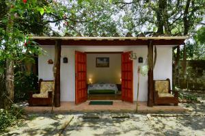 a small room with a bed and two chairs at Casa à beira do rio Jaguareguava na Mata Atlântica em Bertioga SP in Bertioga