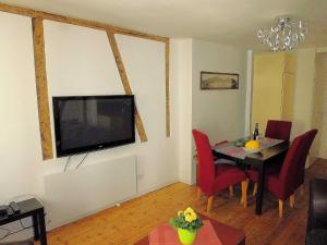 ein Wohnzimmer mit einem Tisch und einem TV an der Wand in der Unterkunft Ferienhaus Jennifer Zell in Zell an der Mosel