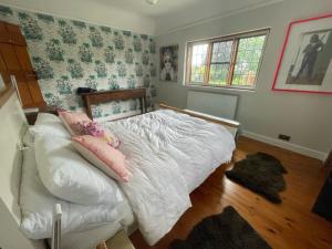 a bedroom with a white bed with pillows on it at Detached Private House in Margate