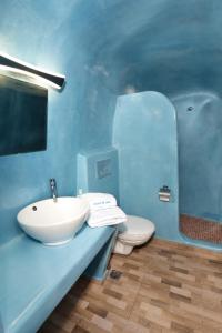 a blue bathroom with a sink and a toilet at Church and Cave - Santorini Private Residences in Mesaria
