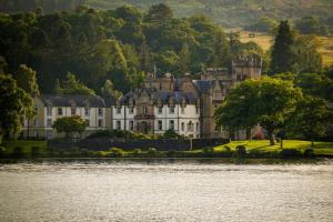 um castelo na costa de um corpo de água em Cameron House on Loch Lomond em Balloch