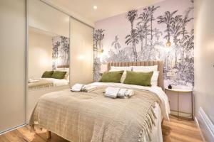 パリにあるNEW Eiffel Tour ! Splendid Apartments in the Heart of Parisのタオルが敷かれた大きなベッドのある寝室