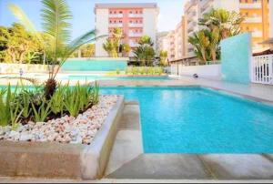 a swimming pool in the middle of a building at APTo 300MTS DA PRAIA, VISTA PARA O MAR, CHURRASQUEIRA, WI-FI, AR CONDICIONADO, TOTALMENTE EQUIPADO in Ubatuba