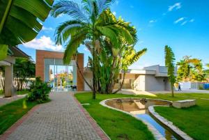a walkway with palm trees in front of a building at APTo 300MTS DA PRAIA, VISTA PARA O MAR, CHURRASQUEIRA, WI-FI, AR CONDICIONADO, TOTALMENTE EQUIPADO in Ubatuba