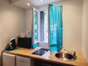 a kitchen counter with a sink and a window at Cosy Corner in LʼIsle-sur-la-Sorgue