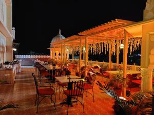 - un restaurant avec des tables et des chaises sur la terrasse le soir dans l'établissement Laxmi Palace Heritage Boutique Hotel, à Jaipur