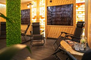 a porch with chairs and a table on a deck at Apartamenty Pod Gubałówką in Zakopane