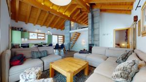a living room with couches and a wooden table at Modern chalet surrounded by nature in Vercorin in Vercorin