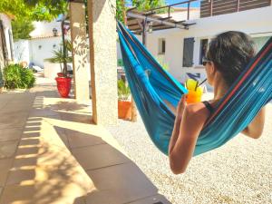 una mujer está sentada en una hamaca azul en VILLA REIALA Carry-le-Rouet, en Carry-le-Rouet