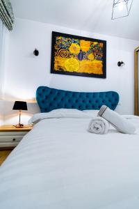 a bedroom with a white bed with a blue headboard at Lighthouse Central Apt with unique views of the Fortress, Free Parking, 5 min by car from the Old Town in Braşov