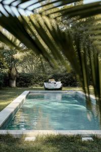 a swimming pool with a boat in a yard at Mas des Prêcheurs in Tarascon