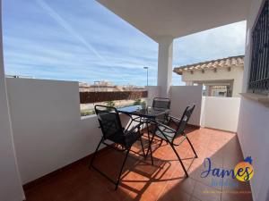 patio con mesa y sillas en el balcón en La Ciñuelica, R3 1st Floor Apartment Com Pool L129, en Torrevieja