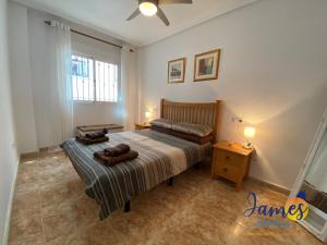 a bedroom with a large bed and a nightstand and a bed sidx sidx sidx at La Ciñuelica, R3 1st Floor Apartment Com Pool L129 in Torrevieja