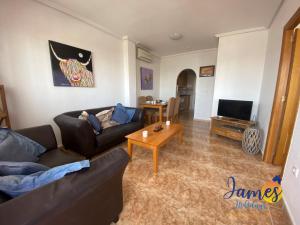 sala de estar con sofá y mesa de centro en La Ciñuelica, R3 1st Floor Apartment Com Pool L129, en Torrevieja