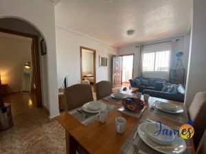 comedor y sala de estar con mesa y sillas en La Ciñuelica, R3 1st Floor Apartment Com Pool L129, en Torrevieja