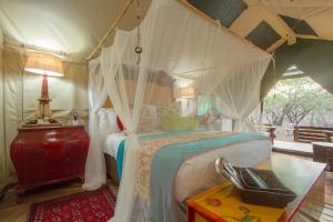 1 dormitorio con cama con dosel en una tienda de campaña en Wielewaal Bush Lodge en Marloth Park