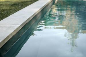 a pool of water with the reflection of a building at Mas des Prêcheurs in Tarascon