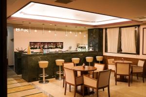 a restaurant with tables and chairs and a bar at Hotel Antoniadis in Kalabaka