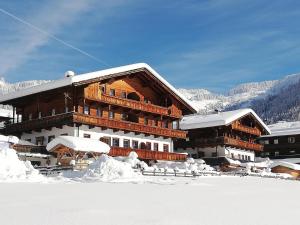 un gran edificio de madera con nieve en el suelo en Appartement Moaeben - Panorama en Alpbach