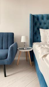 a blue chair and a table next to a bed at Opera Center Hotel & Apartments in Lviv