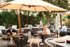 a group of people sitting at an outdoor restaurant with a dog at Palazzo Barocci in Venice