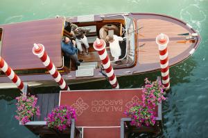 Un gruppo di persone su una barca in acqua di Palazzo Barocci a Venezia