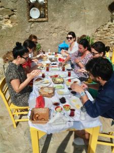 a group of people sitting around a table eating food at SARI KEÇİ TAŞ OTEL in Gokceada Town +53 photos