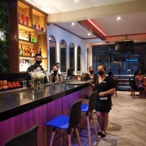 a group of people standing at a bar at FH Hotel in Iquitos