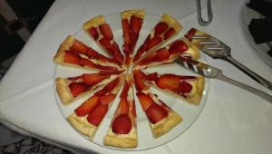 a plate with a fruit pizza on a table at Hotel Diplomat Palace in Rimini