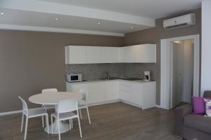 eine Küche und ein Wohnzimmer mit einem Tisch und einem Sofa in der Unterkunft Residence VILLA ADRIANA in Bardolino