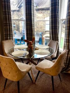 een eetkamer met een glazen tafel en stoelen bij Merewyke Boutique Luxury Family Apartment Sleeps 4 , Central Location in Windermere