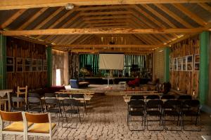 an empty room with chairs and tables and a projection screen at Rajski Staw in Zajki