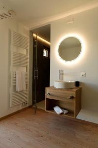 ein Bad mit einem Waschbecken und einem Spiegel in der Unterkunft Hotel Bernina in Pontresina