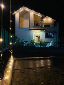 uma casa com luzes à frente à noite em Bliss Villa 6Bhk Alibaug 1 Min Walking Distance To Kihim Beach em Alibaug