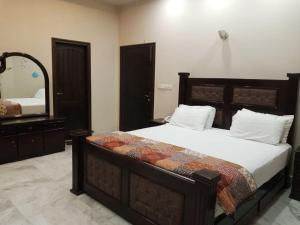 1 dormitorio con 1 cama grande y espejo en HOTEL STATE RESIDENCY, en Bahawalpur